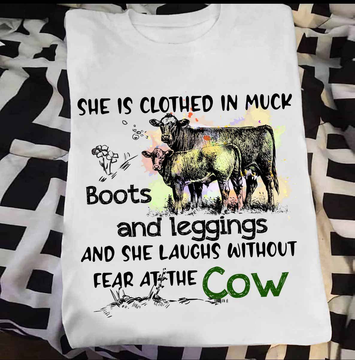 She is clothed in muck boots and legging and she laughs without fear at the cow - Woman loves cows