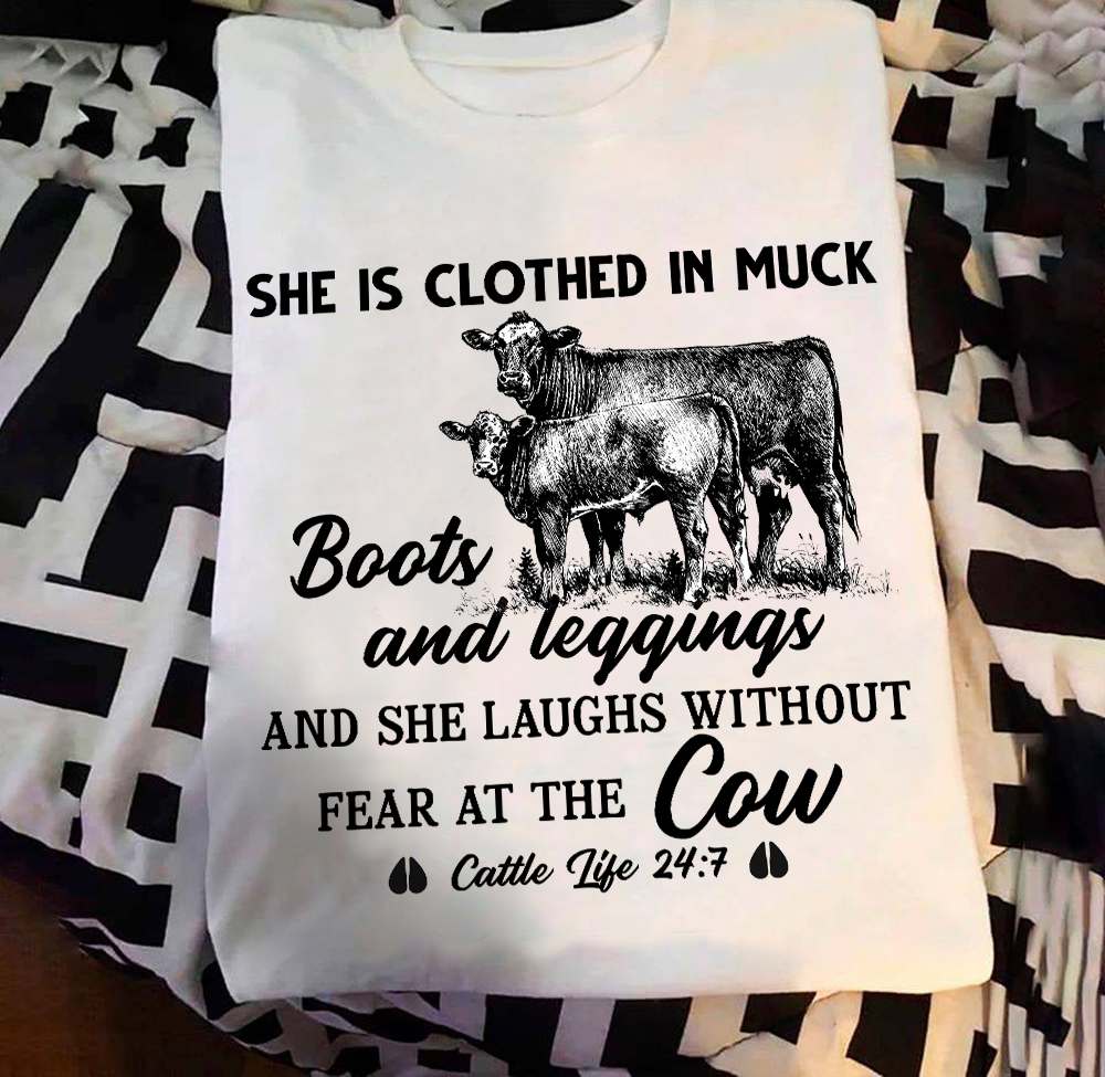 She is clothed in muck boots and legging and she laughs without fear at the cow